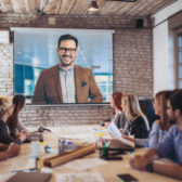 Business people looking at projector during video conference in office