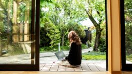 a-female-guest-working-on-the-porch-of-the-guesthouse-where-she-stayed-during-her-trip-to-japan-stock-photo.jpeg