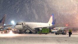 airplane-parked-snow-airport.jpeg