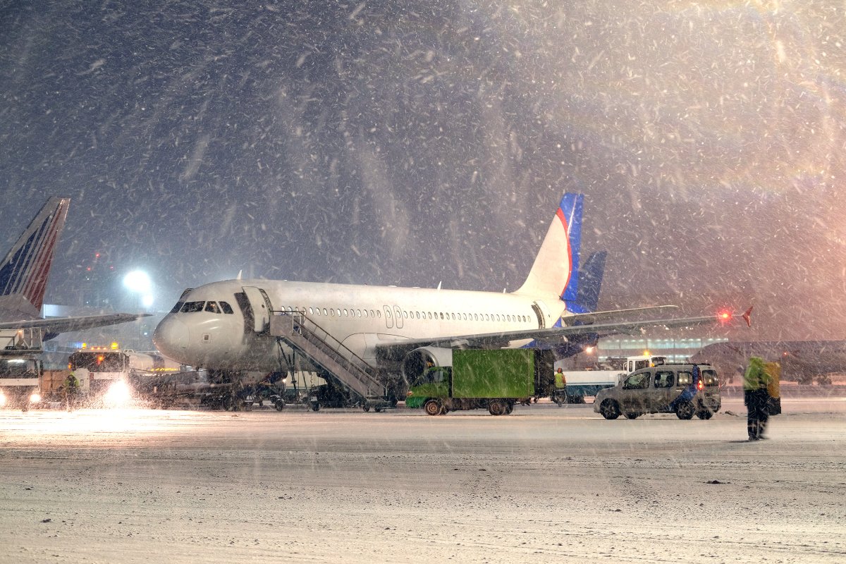 airplane-parked-snow-airport.jpeg