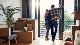 couple_at_window_with_moving_boxes_in_new_home_Z7GTaRw.jpeg