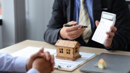 Real estate agent discussing about the terms of the purchase agreement and sign the documents to make the contract legally. Home sales, renting, leasing, mortgage and home insurance concept.