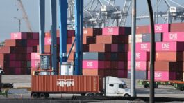 0829e1-20260903-a-truck-moves-goods-on-a-port-full-of-stacked-shipping-containers-2000
