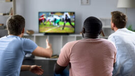 Fans Deliver Big Ratings for NFL Kickoff on Broadcast TV - NAB Blog Male friends gather to watch football competition on big screen,