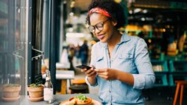Young,African,Woman,Smiling,While,Sitting,Alone,At,A,Counter Young,African,Woman,Smiling,While,Sitting,Alone,At,A,Counter