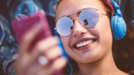 Attractive young woman listening to music on her smart phone